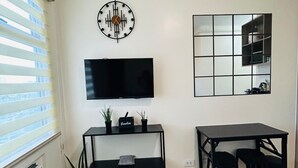 Une chambre à coucher avec un lit, une télévision, un bureau et un miroir.