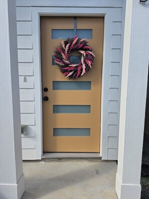 A front door with a wreath, a vertical window, and a mailbox. - Pleasant 3-bedroom house with AC in vibrant Houston (Houston)