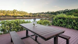 A wooden deck with a table and benches overlooking a body of water. - Charlie Bravo Chalet—Escape to the Golden Triangle (Margaret River)