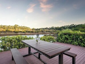 A wooden deck with a table and benches overlooking a body of water. - Charlie Bravo Chalet—Escape to the Golden Triangle (Margaret River)