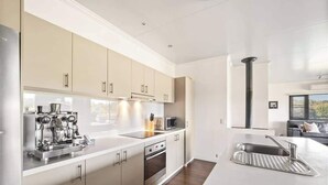 A modern kitchen with stainless steel appliances, a built-in oven, and a microwave. - Charlie Bravo Chalet—Escape to the Golden Triangle (Margaret River)