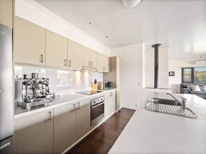 A modern kitchen with stainless steel appliances, a built-in oven, and a microwave. - Charlie Bravo Chalet—Escape to the Golden Triangle (Margaret River)