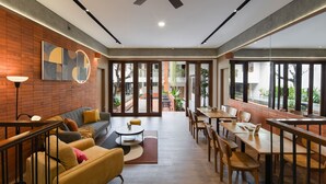 Un interior moderno con comedor, asientos y vistas al exterior.