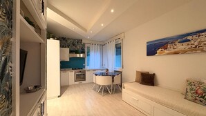 A compact living space with a kitchenette, dining area, and a sofa.