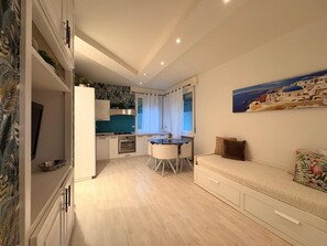 A compact living space with a kitchenette, dining area, and a sofa. - Lake Retreat (Brusimpiano)