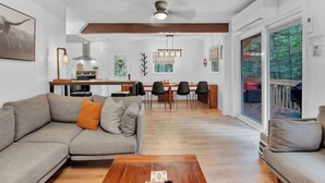 A modern living room with a sofa, coffee table, and dining area with chairs and a table. - Horizon Hideaway Hot Tub Fire Pit Game Room (Long Pond)