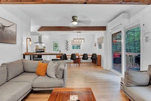 A modern living room with a sofa, coffee table, and dining area with chairs and a table. - Horizon Hideaway Hot Tub Fire Pit Game Room (Long Pond)