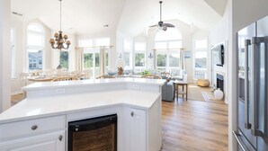 Un'ampia cucina con una grande isola, un'area pranzo con vista e una ventola a soffitto.