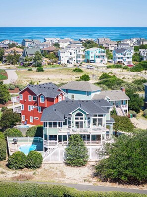 A coastal residential area with houses, a swimming pool, and a view of the ocean. - Newly Renovated: Pool/Spa, GameRm, Community Perks (Corolla)