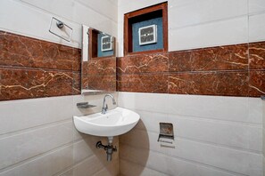 A bathroom with a white sink, a mirror, and a ventilation system.