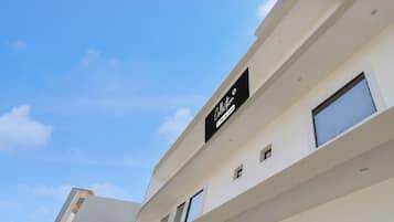 A modern building with a sign indicating it is a serviced apartment.