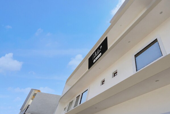 A modern building with a sign indicating it is a serviced apartment.