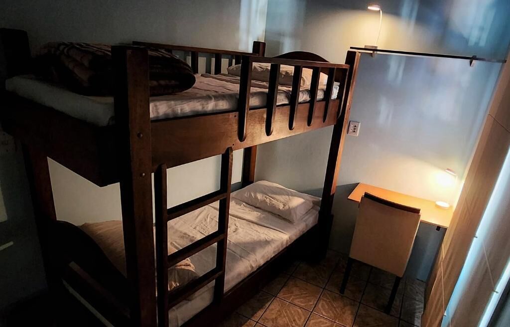 Dormitorio con literas, escritorio y lámpara.