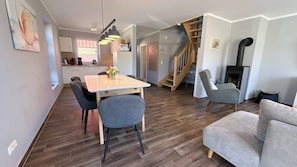A modern interior with a dining area, a staircase, and a living room. - Vacation apartment Muschel Bauernhof-Claussen (Fehmarn)