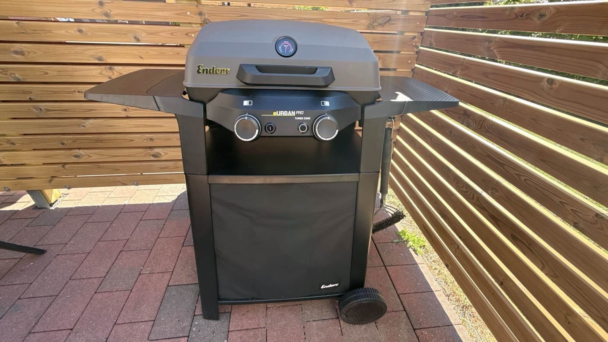 A black eUrban Pro Turbo Zone grill with a control panel, placed outdoors on a paved surface.
