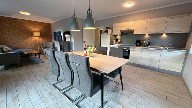 Et moderne køkken med spiseplads, sofa og pejs.