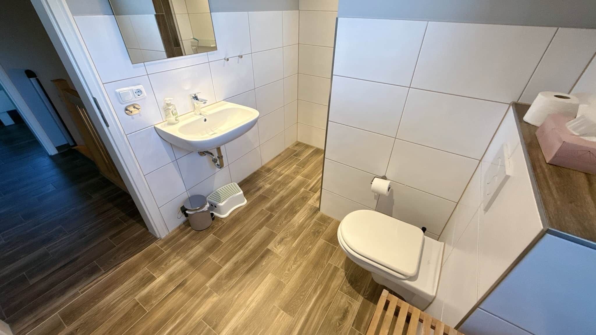A modern bathroom with a sink, toilet, and shower area.