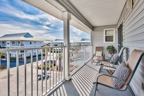 Ein Balkon mit Blick auf einen Pool und andere Gebäude.