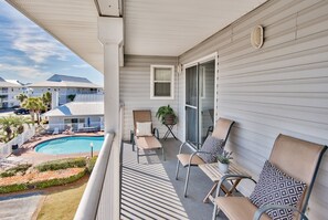 Ein Balkon mit Pool, Liegestühlen und einer Topfpflanze.