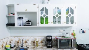 A kitchen with white cabinets, a microwave, a coffee maker, and a blender. - La Casona Blanca (San Marcos)
