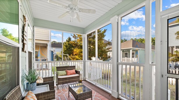 A covered porch with wicker furniture, a ceiling fan, and large windows offering views of the neighborhood. - Golf Cart/Bikes! Dune Allen 30A. Pool Access. (Santa Rosa Beach)