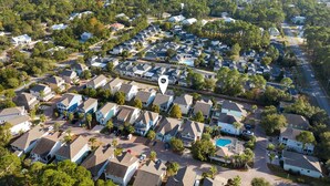 An aerial view of a residential area with houses, roads, and a body of water in the background. - Golf Cart/Bikes! Dune Allen 30A. Pool Access. (Santa Rosa Beach)