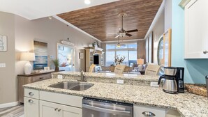 A modern kitchen with granite countertops, stainless steel appliances, and a built-in dishwasher. - Private Beach! Chair setup! Penthouse. Destin! (Destin)