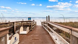 A wooden boardwalk leading to a beach with a sign indicating 'Rip Currents' and 'No Swimming'. - Private Beach! Chair setup! Penthouse. Destin! (Destin)