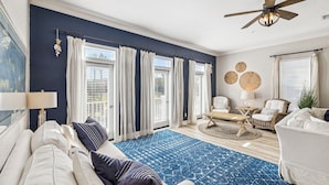 A living room with a blue rug, white sofas, and a ceiling fan. - Updated! Beach Access - Pool - Walkable Dining (Santa Rosa Beach)