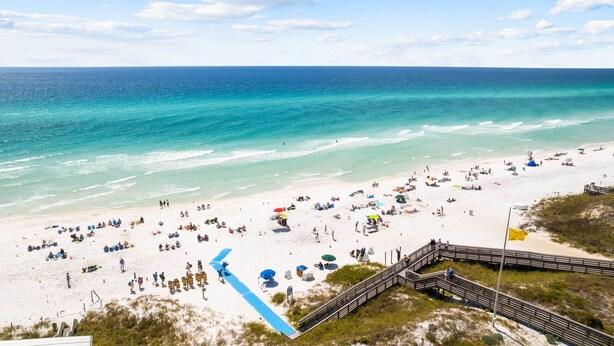 A beach with a wooden boardwalk leading to the water, clear skies, and a sandy shore with umbrellas and people. - Updated! Beach Access - Pool - Walkable Dining (Santa Rosa Beach)