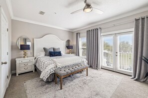 A bedroom with a bed, bedside tables, a bench, a ceiling fan, and a view through the window. - Updated! Beach Access - Pool - Walkable Dining (Santa Rosa Beach)