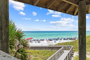 A beach with a wooden walkway leading to the shore, umbrellas, and people relaxing. - Updated! Beach Access - Pool - Walkable Dining (Santa Rosa Beach)