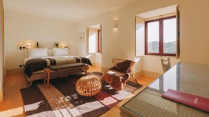 A bedroom with a bed, a chair, a table, and a window. - Casa Villae Relais & Châteaux - The most charming house in the Dão region (Silvã de Cima)