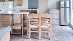 Una cocina moderna con comedor, armarios de madera y estufa integrada.
