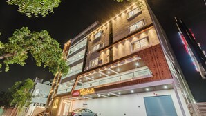 A multi-story hotel with a sign reading 'Hotel Rasbello,' balconies, and a garage. - Hotel Rasaballa grand (Kothagudem)
