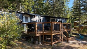 Eine Holzhütte mit einer Holzterrasse, umgeben von Bäumen.
