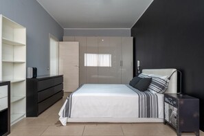 Ein modernes Schlafzimmer mit einem Bett, einem Schminktisch, einem Kleiderschrank und einem kleinen Schrank.