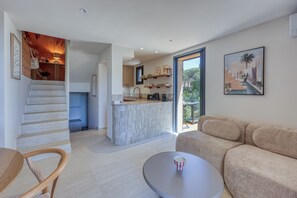 A modern interior with a staircase, a kitchen area, a dining table, and a sofa. - Lou Mazet 24, Charming house with sea view and Saint-Tropez (Sainte-Maxime)