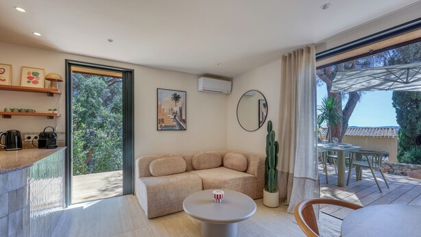 Un salon moderne avec un canapé, une table basse et un coin repas.