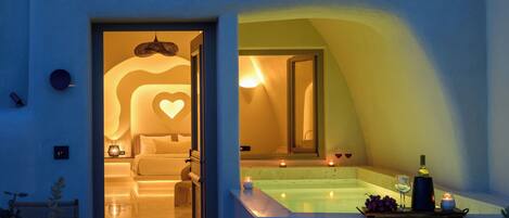 A hotel interior with a spa area, a bedroom, and a bathroom.