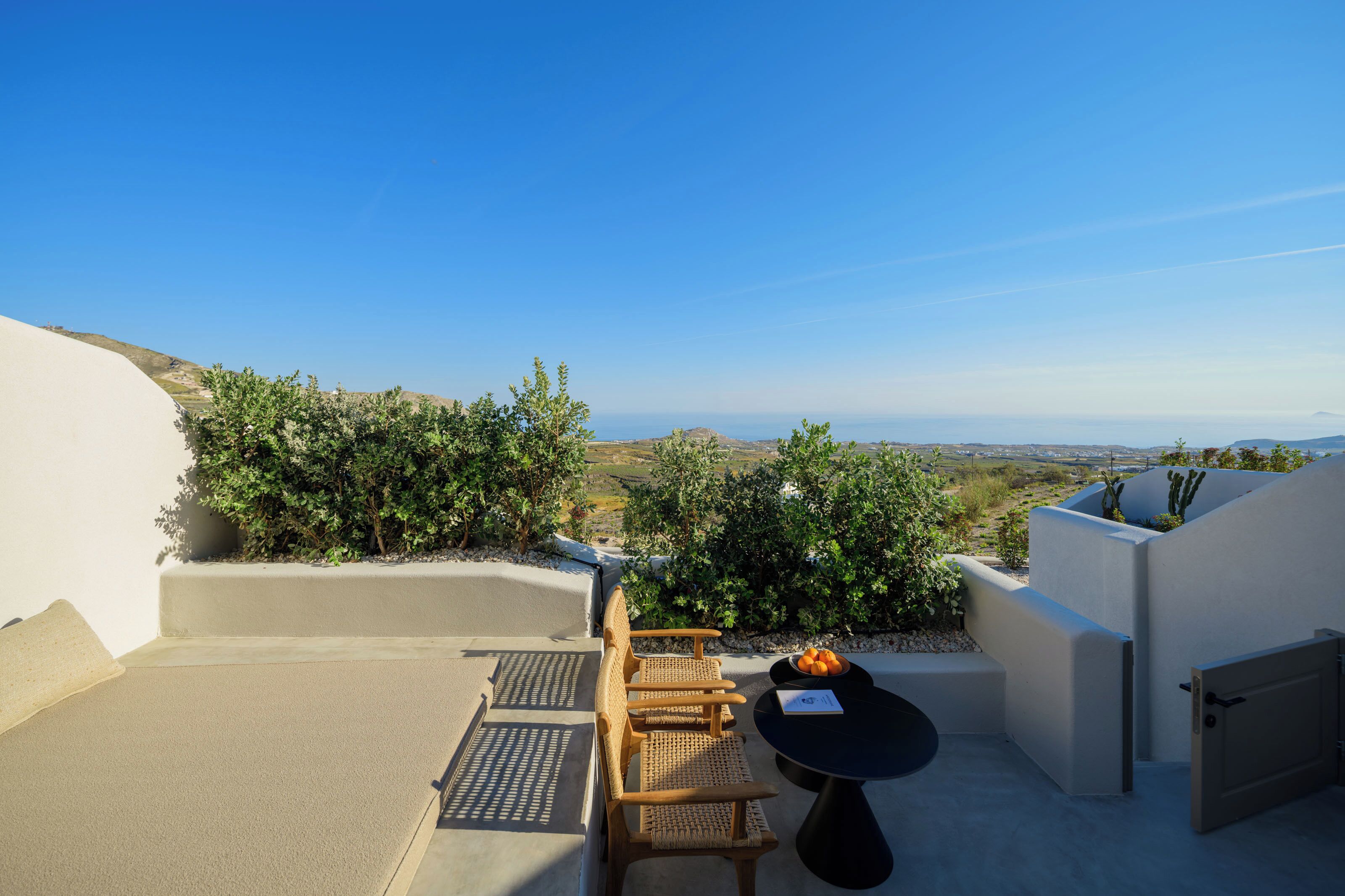 Una terraza en la azotea con una mesa, sillas y vistas al paisaje.