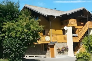 A traditional wooden building with a balcony, a staircase, and a stone wall. - 2-Room Apartment for 4 – Châtel – Balcony, Parking, Near the Slopes (Châtel)
