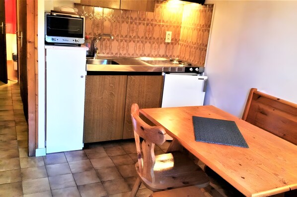 A compact kitchen with a microwave, sink, and wooden cabinets. - 2-Room Apartment for 4 – Châtel – Balcony, Parking, Near the Slopes (Châtel)