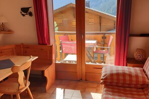 A wooden interior with a dining table, chairs, and a sofa. - 2-Room Apartment for 4 – Châtel – Balcony, Parking, Near the Slopes (Châtel)