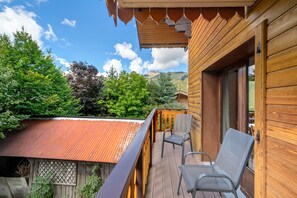A wooden balcony with a metal railing, a chair, and a view of a mountain landscape. - Apartment for 5 in Châtel – Near Slopes, Balcony, Free Private Parking (Châtel)