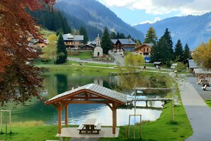 A lakeside village with wooden buildings, a gazebo, and a small church. - Apartment for 5 in Châtel – Near Slopes, Balcony, Free Private Parking (Châtel)