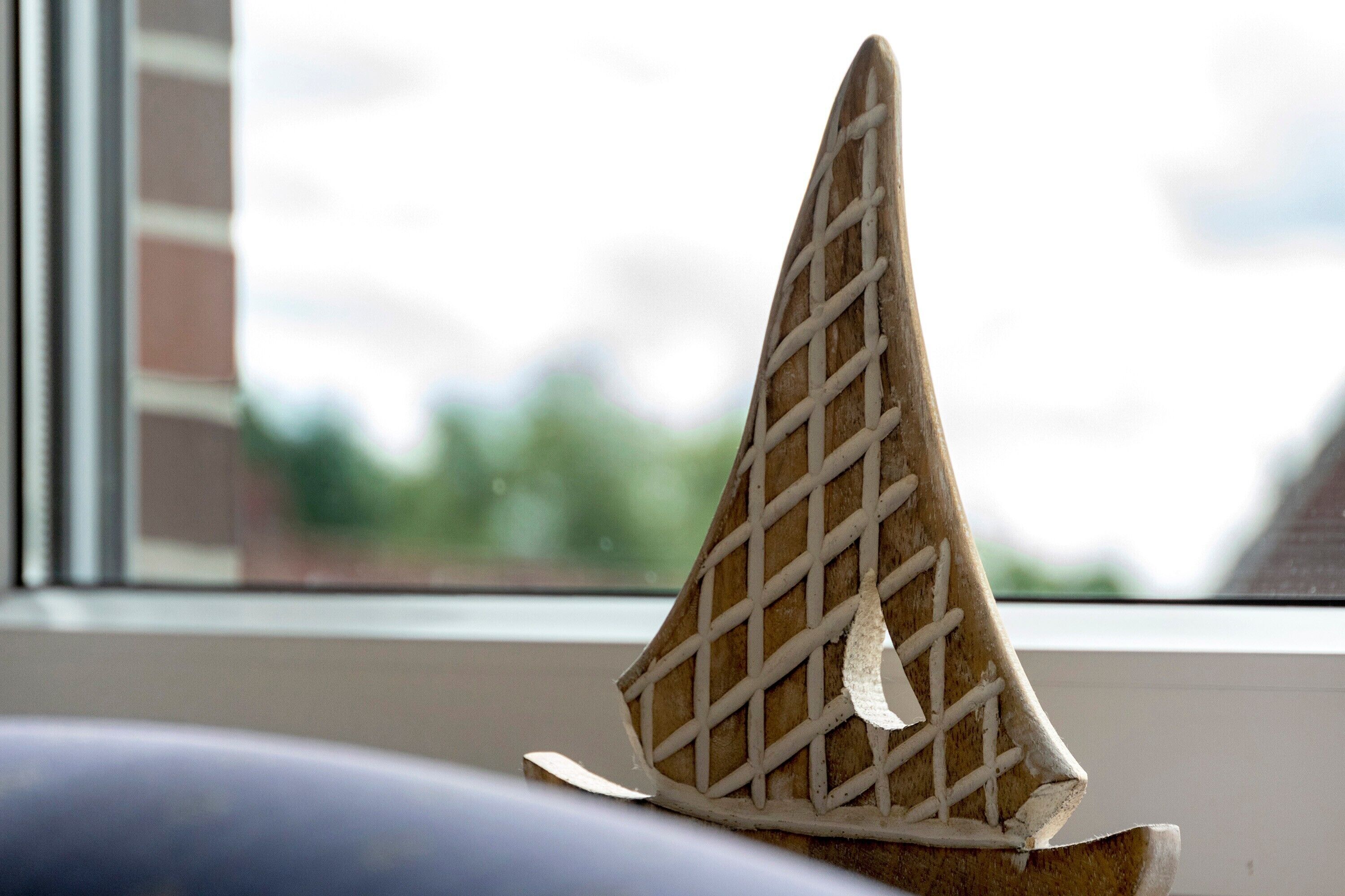 Ein Waffelhorn auf einem Tisch in der Nähe eines Fensters mit unscharfem Blick ins Freie.