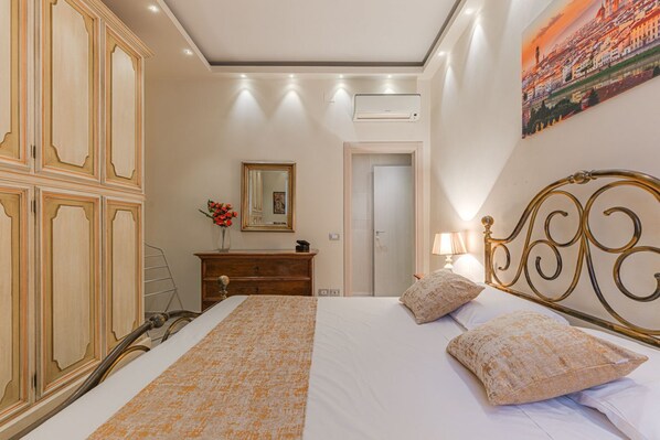 A bedroom with a bed, a dresser, a mirror, and a door.