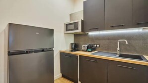 A compact kitchen with a refrigerator, microwave, coffee maker, and a sink. - AN UNBEATABLE LOCATION IN THE HEART OF ONE OF PARIS'S MOST VIBRANT DISTRICTS (Paris)