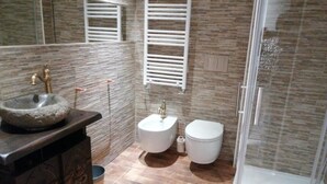 A bathroom with a stone sink, two toilets, a shower, and a decorative cabinet. - Tenuta Borgato Morelli (Este)